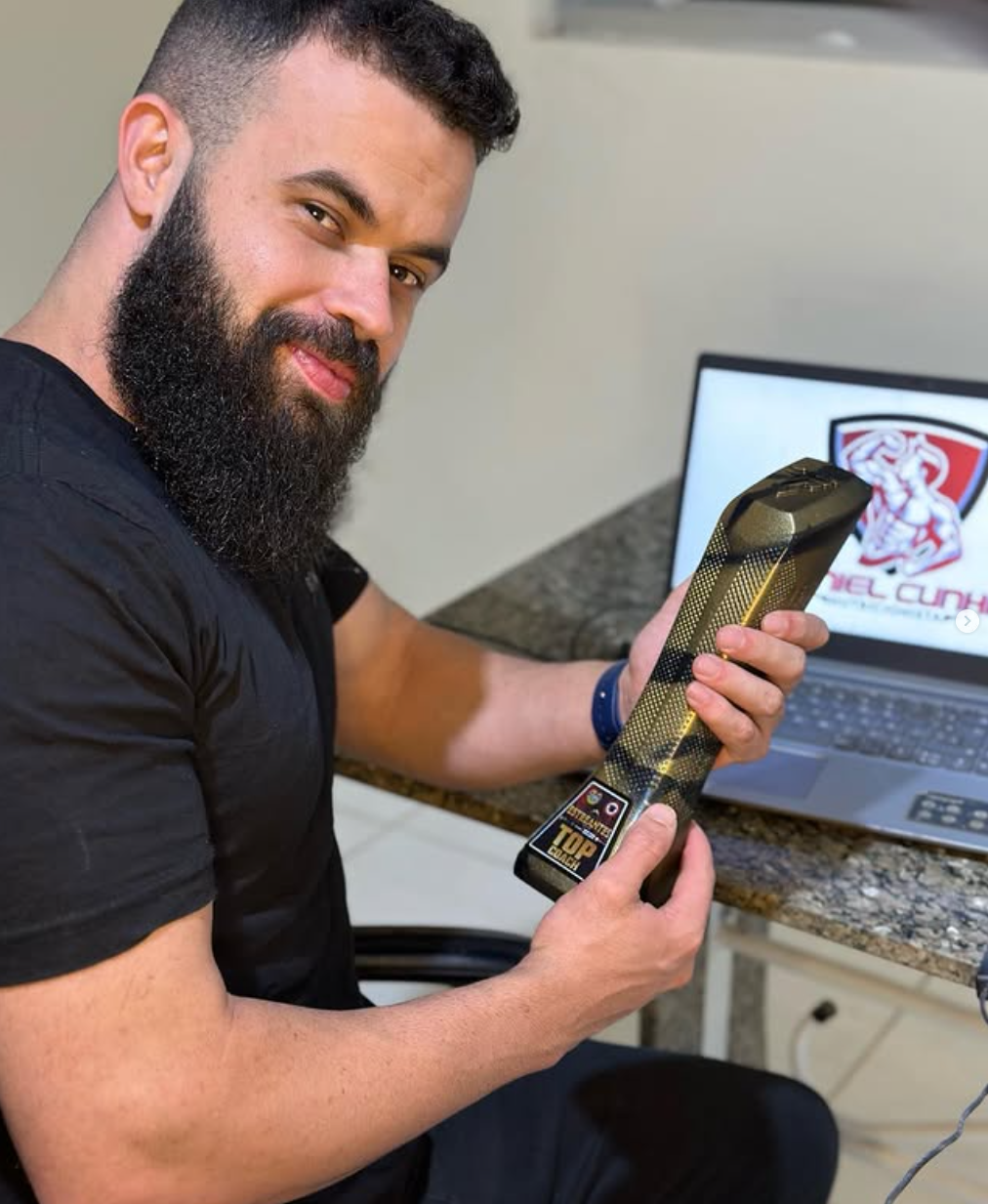 Daniel Cunha sorrindo enquanto segura o troféu Top Coach Estreantes 2024